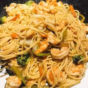 A plate of noodles with shrimp and broccoli.