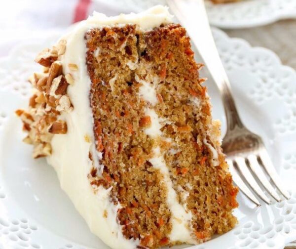 A piece of carrot cake with white frosting on top.