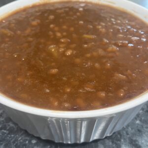 A bowl of chili with beans on top.