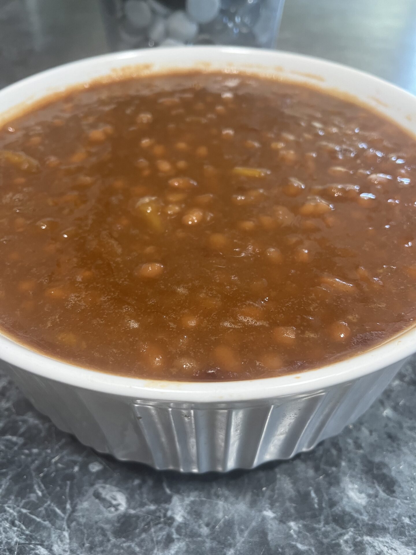 A bowl of chili with beans on top.