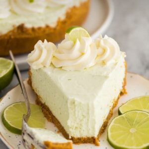 A slice of key lime pie on top of a white plate.