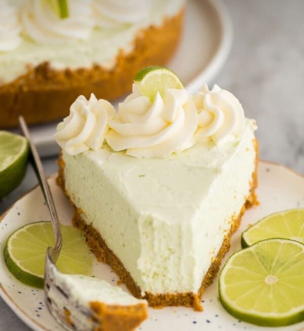 A slice of key lime pie on top of a white plate.