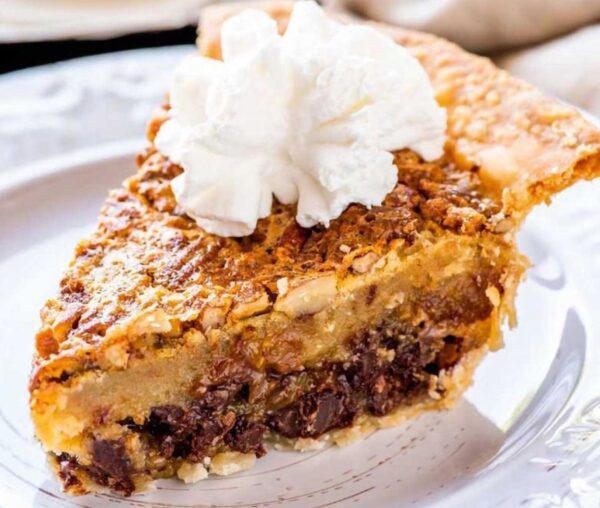 A slice of pie with whipped cream on top.