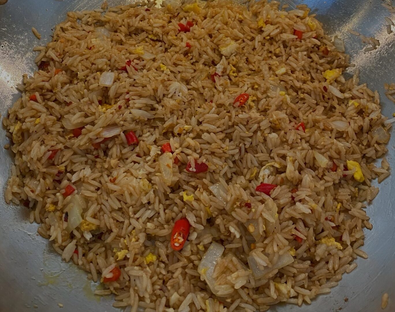 A bowl of rice with meat and peppers.