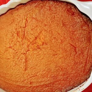 A close up of an orange cake in a pan