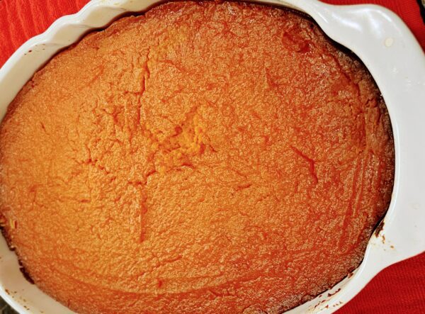 A close up of an orange cake in a pan