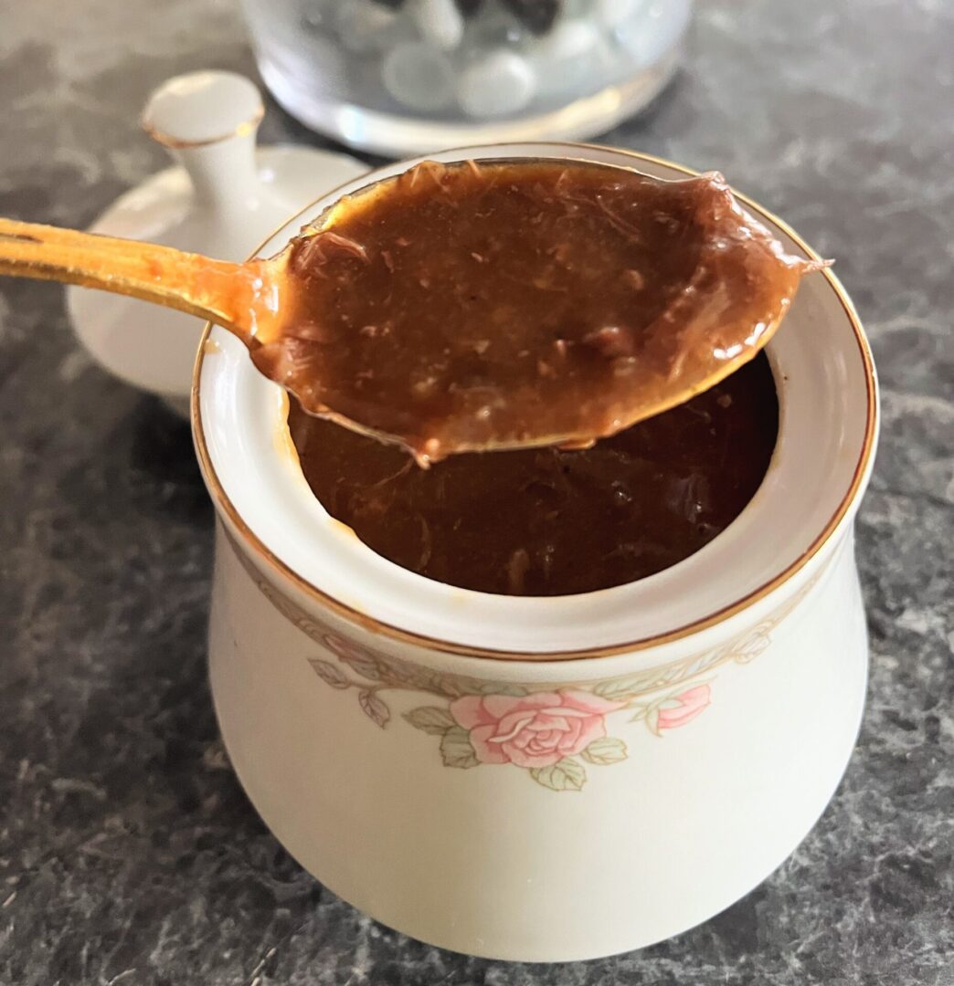 A spoon in a bowl of coffee on the counter.