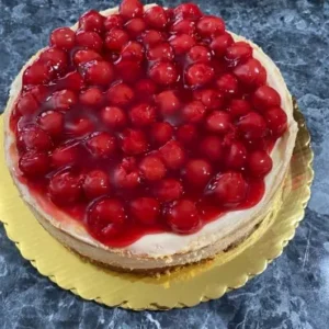 A cheesecake with cherries on top of it.