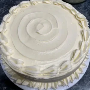 A white cake with icing on top of it.