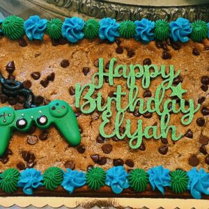 A birthday cake with cookies and frosting on it.