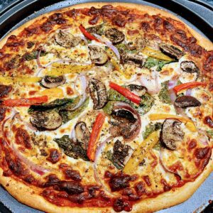 A pizza with mushrooms, peppers and onions on it.