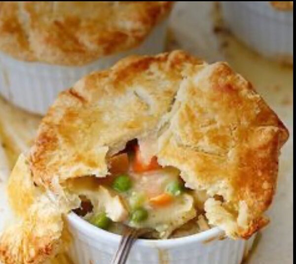 A close up of a pot pie in a white bowl