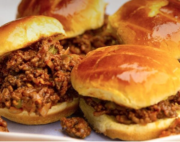 A plate of sandwiches with meat and buns.