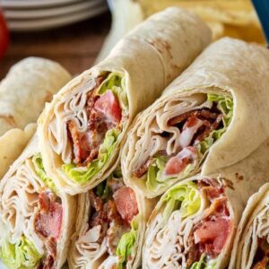 A close up of a wrap filled with meat and lettuce