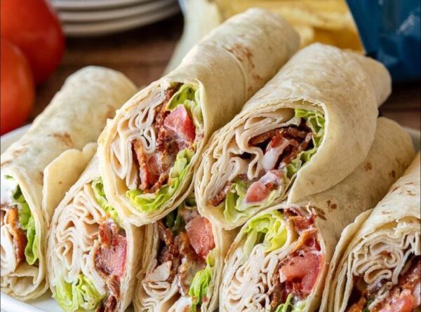 A close up of a wrap filled with meat and lettuce