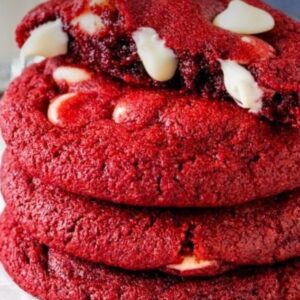 A stack of red velvet cookies with white chocolate chips.